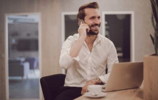 Freelancing - a man talking on the phone sitting at his desk