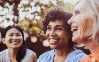 Three women in a park smiling