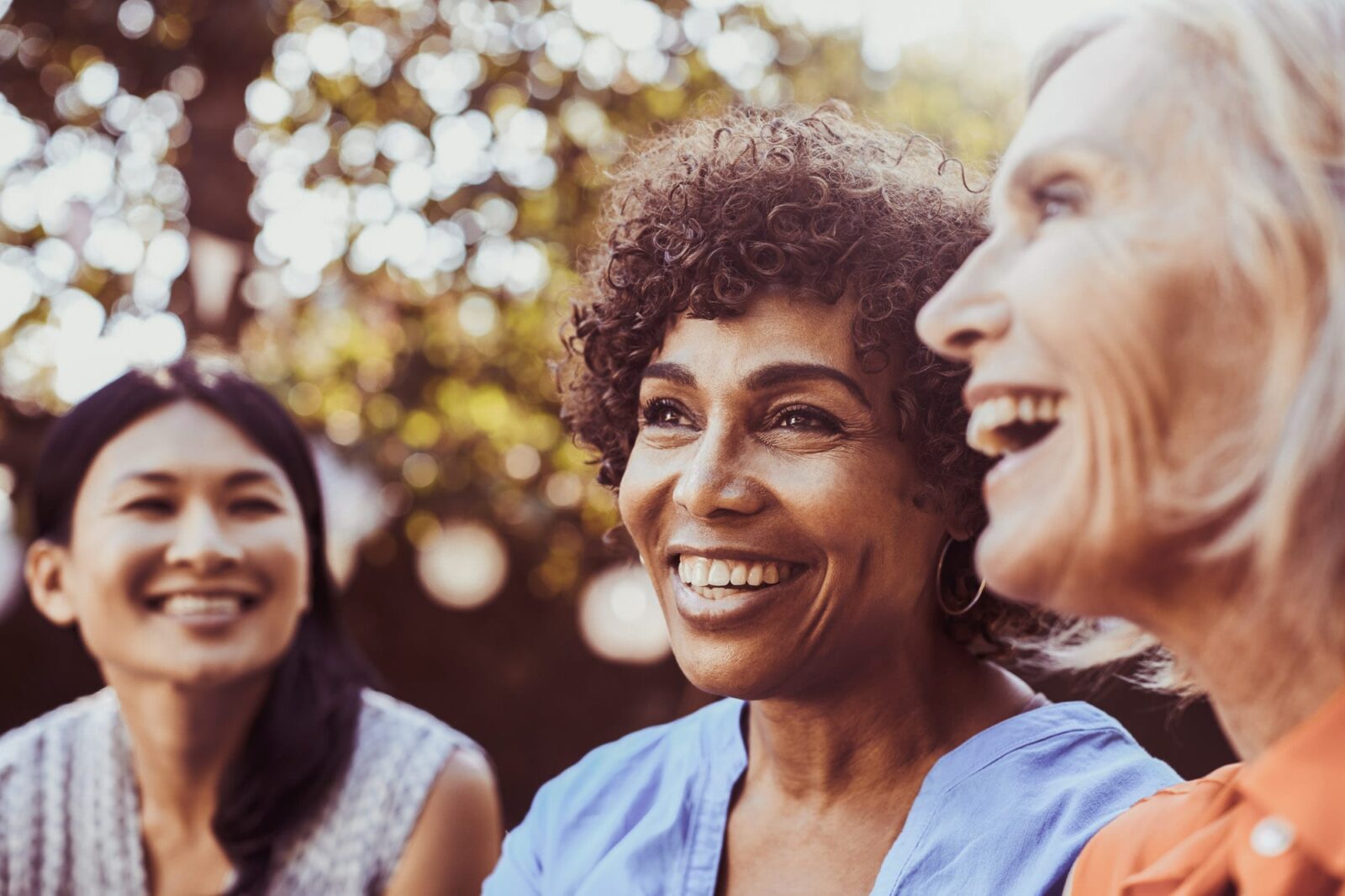 Three women in a park smiling