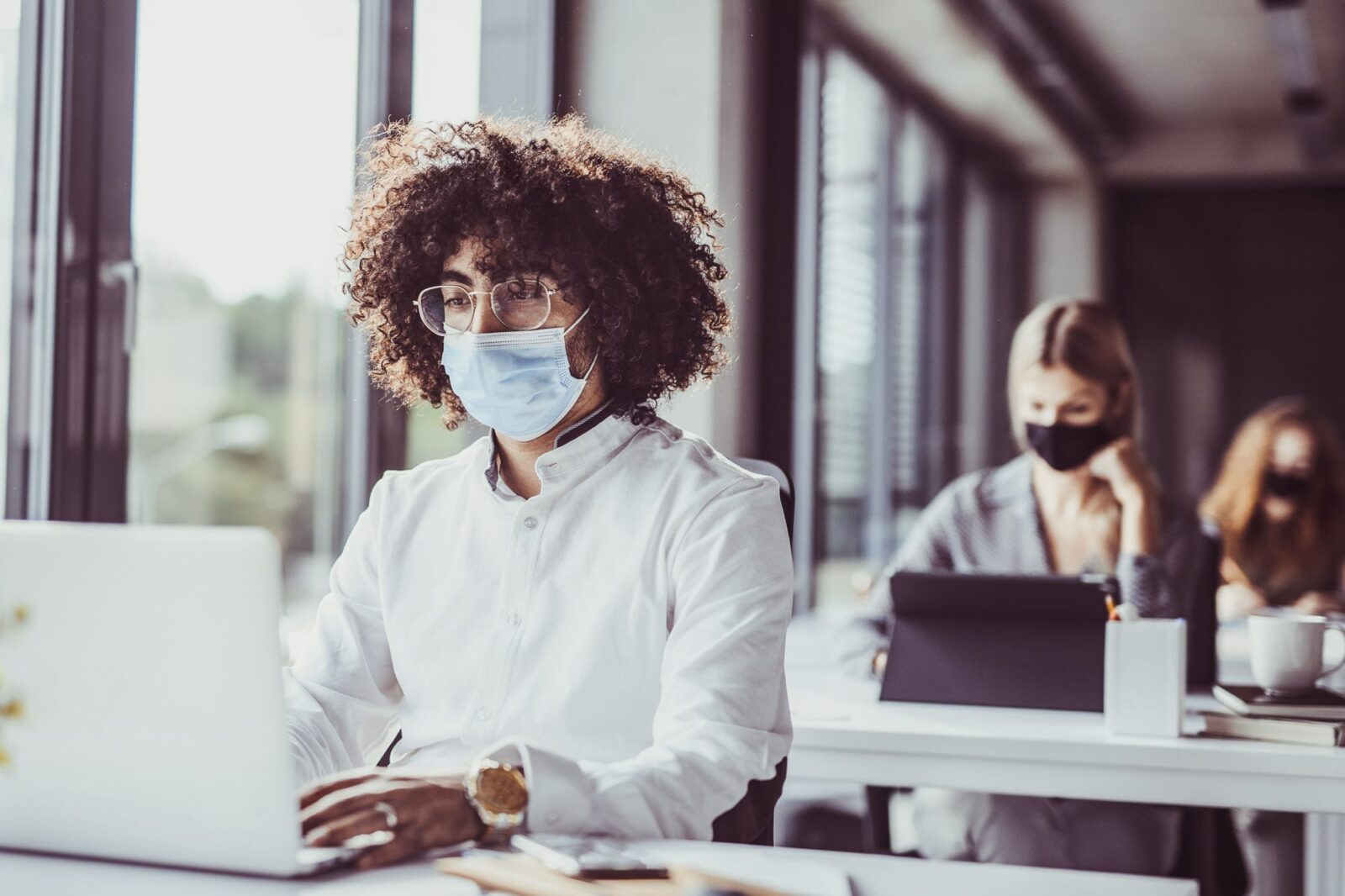 Man sitting at a desk working wearing a face mask